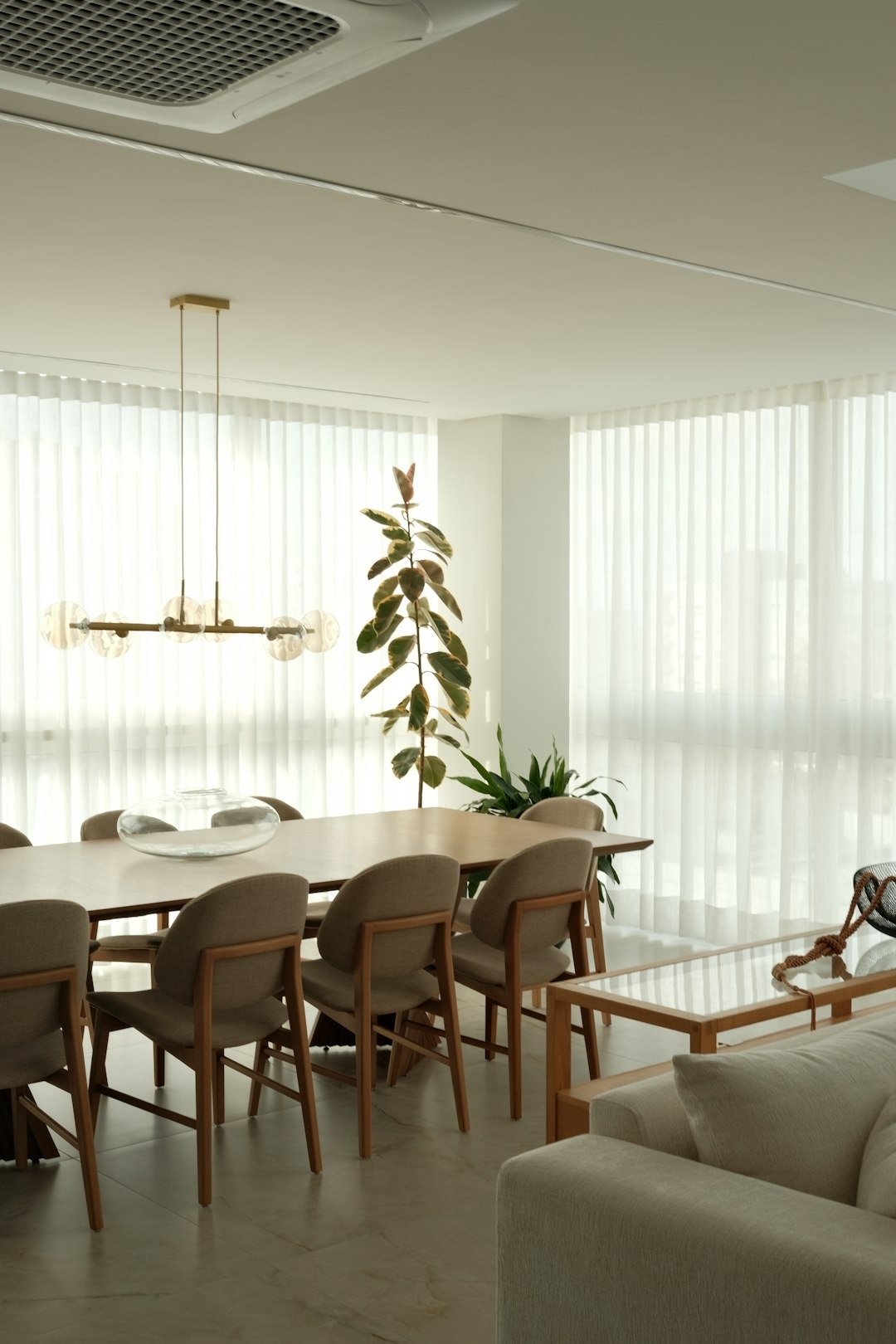 Modern dining room with bright sunlight and elegant furniture.